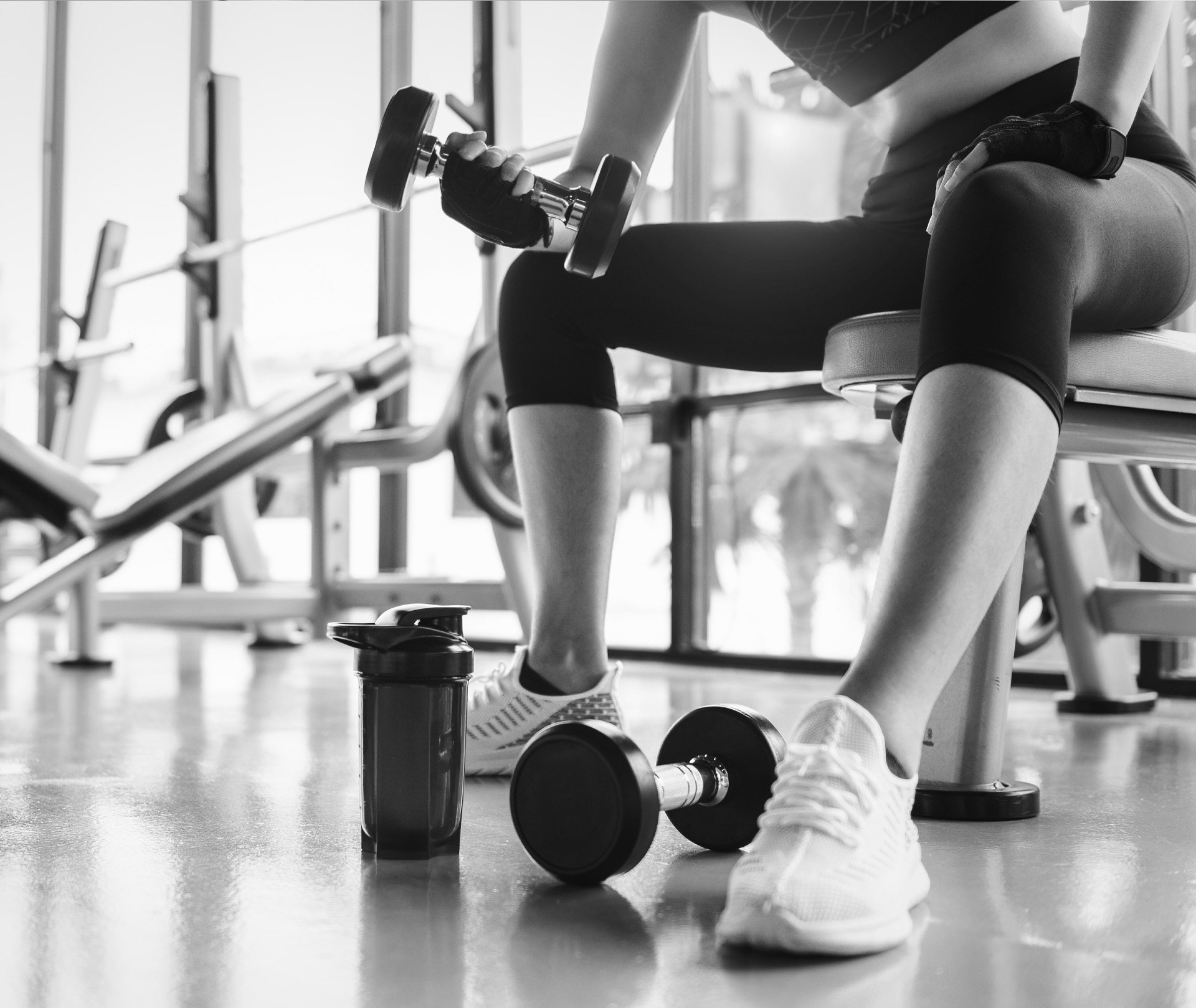 Frau sitzend mit Hantel trainierend