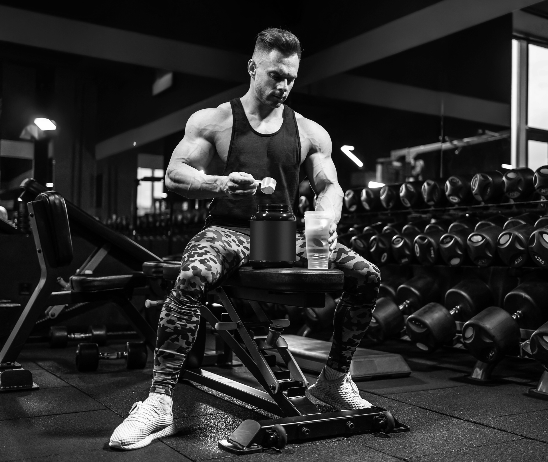 Bodybuilder sitzt und befüllt seinen Shaker im Fitnessstudio